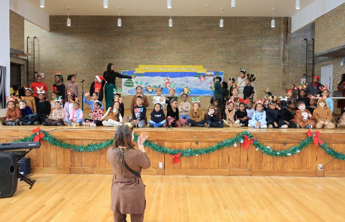 kids on a stage singing a song. 